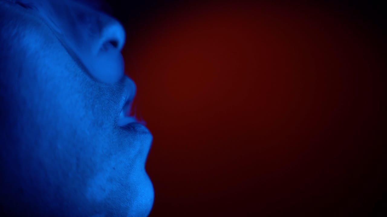 macro en cámara lenta del humo creciente del cigarrillo dentro de la discoteca de fiesta - mujer iluminada en color azul