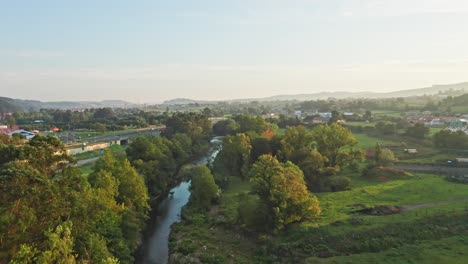 river with vegetation flowing parallel to highway in northern spain with an idyllic sunset light