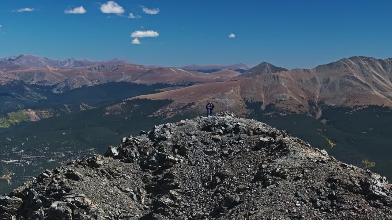 Hikers reach the top of Peak 10 Trail, surrounded by breathtaking Colorado mountain scenery