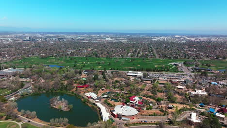 City Park Golf Course Denver Colorado Lake Pavilion vibrant spring summer aerial drone sunny blue sky front range cityscape green lush grass trees blossom circle left motion