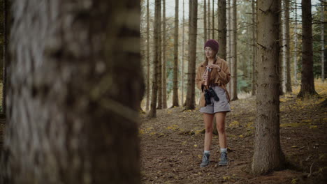 woman opening bottle lid while exploring in forest