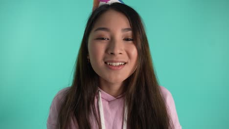 기쁜 아시아 여성 생일에 반이는 불꽃을 불어넣습니다.