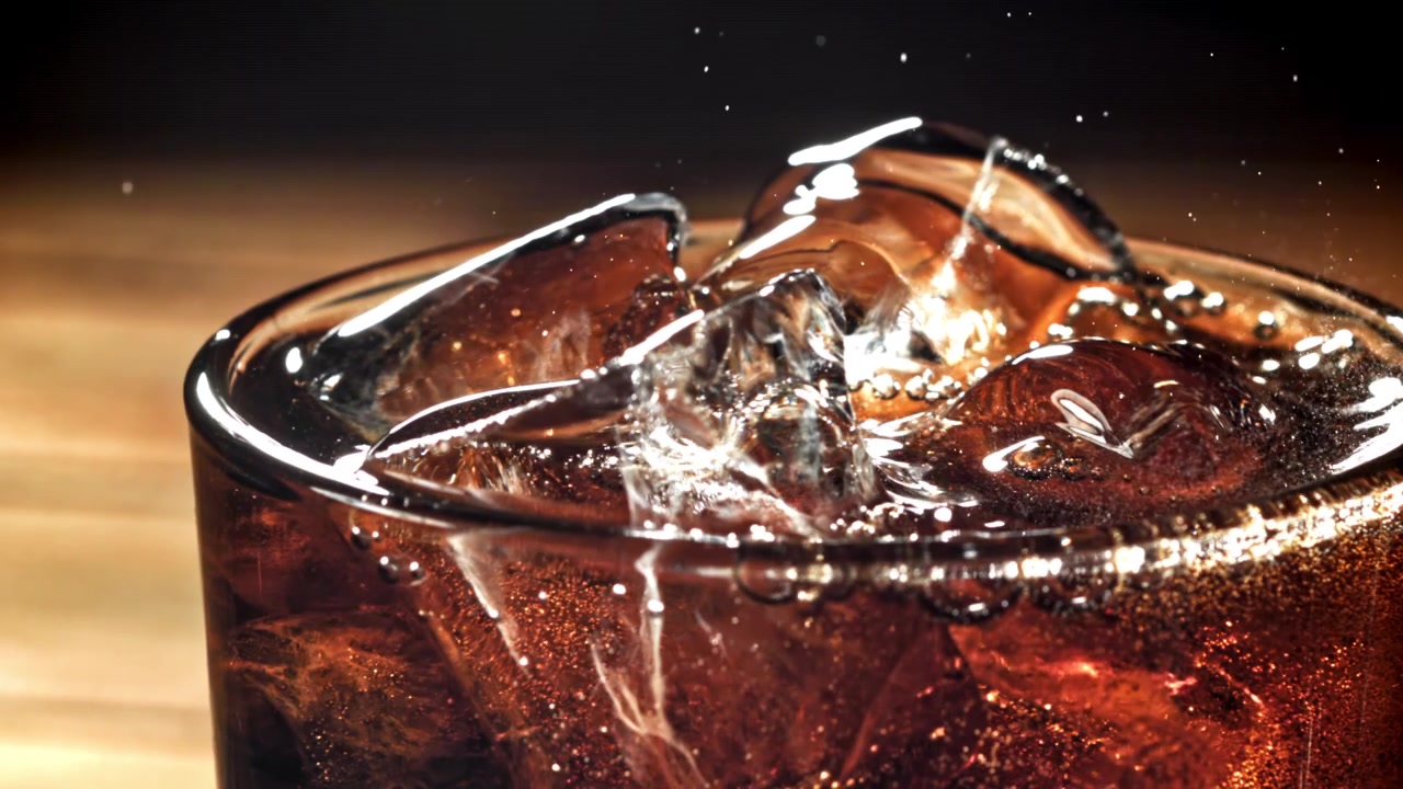 Primo piano di cola rinfrescante con cubetti di ghiaccio e bollicine