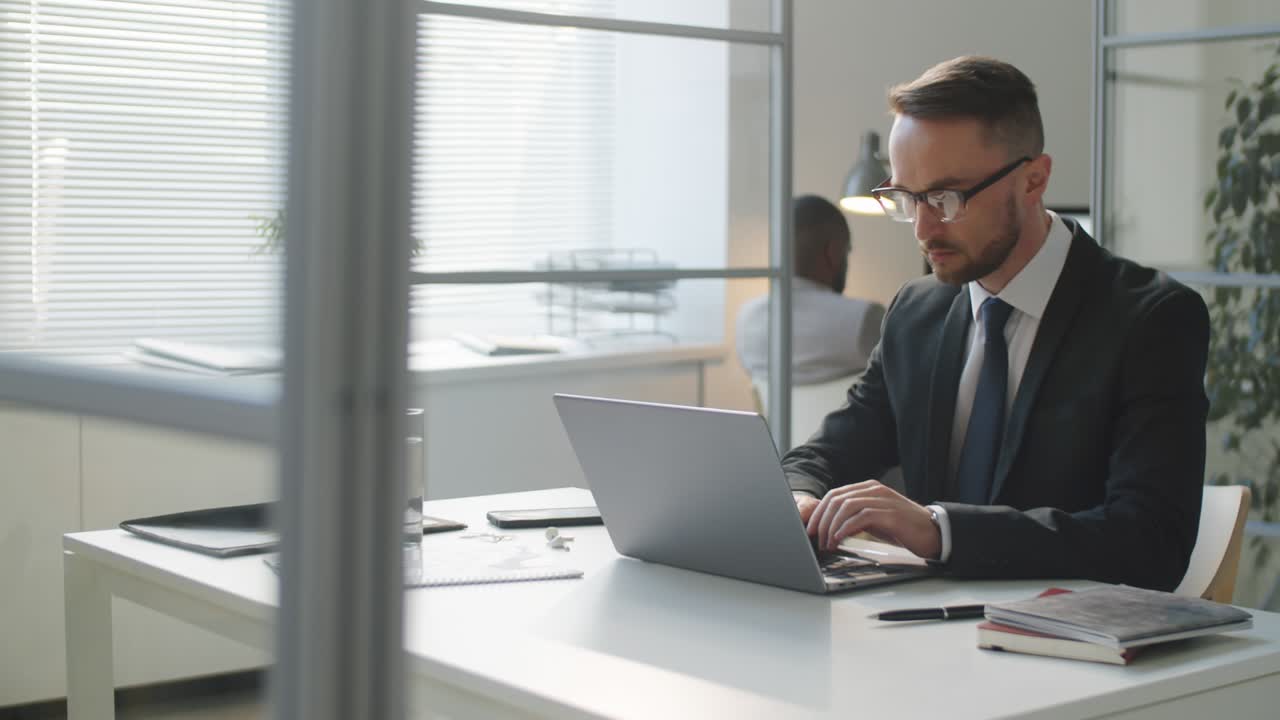 Caucasian Businessman Working on Laptop at Office Desk