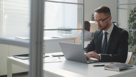 caucasian businessman working on laptop at office desk