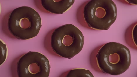 chocolate glaze donuts on a pink background