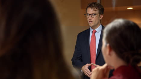 vista sobre el hombro de un joven empresario hablando en una reunión