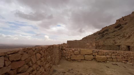 Panoramic-view-of-Ksar-Guermessa-troglodyte-village-in-Tunisia-with-cloudy-dramatic-sky