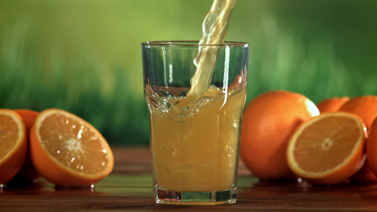 Fresh Orange Juice Pouring into a Glass in Slow Motion