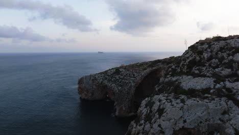 Aerial-view-around-rocky-cliffs-on-the-coast-of-the-Malta-island,-sunny-evening