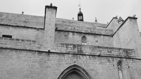 detalle arquitectónico de ángulo bajo de la iglesia parroquial de santa maría en sagunto, españa en blanco y negro.