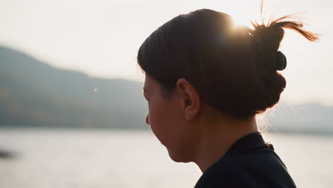 woman looking out at lake sunset