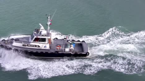 aerial view of water pilot vessel under power with bow spray