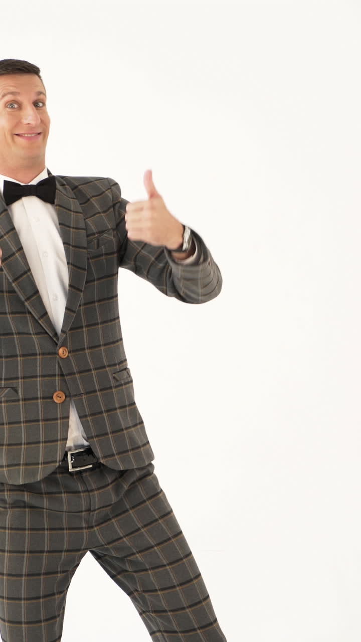 charismatic man in a plaid suit is depicting a cheerful and serious facial expression with gesticulating of hands on a white background Vertical video