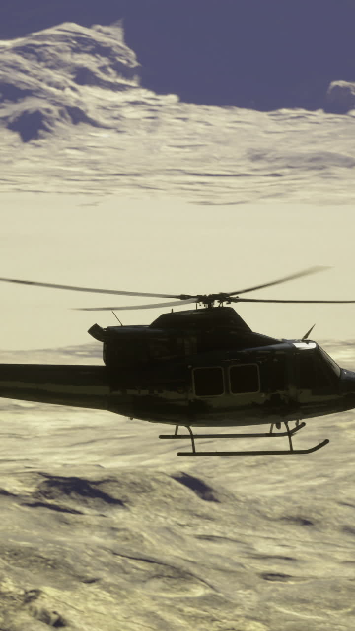 Helicopter flying over snowy mountains in a rugged wilderness landscape