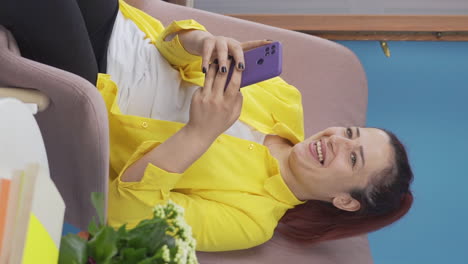 vertical video of woman texting with happy expression.