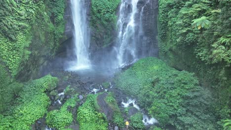 persona acercándose a una gran cascada - cascada sekumpul