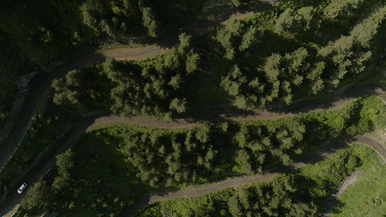 drone ascendiendo en la carretera de montaña con la conducción de automóviles en dirección a la aldea de apnia, georgia
