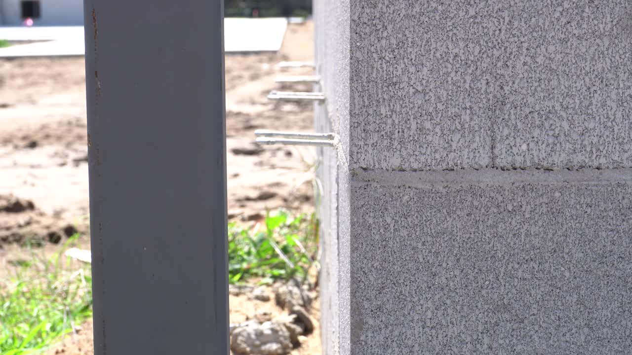 cerca de una pared de ladrillos mientras está en construcción