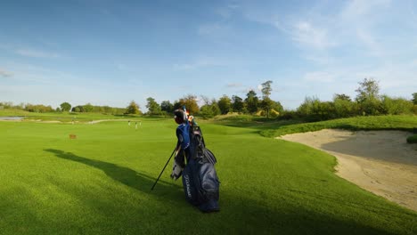 A-Staff-Bag-Positioned-Near-a-Bunker-on-the-Golf-Course---Drone-Flying-Forward