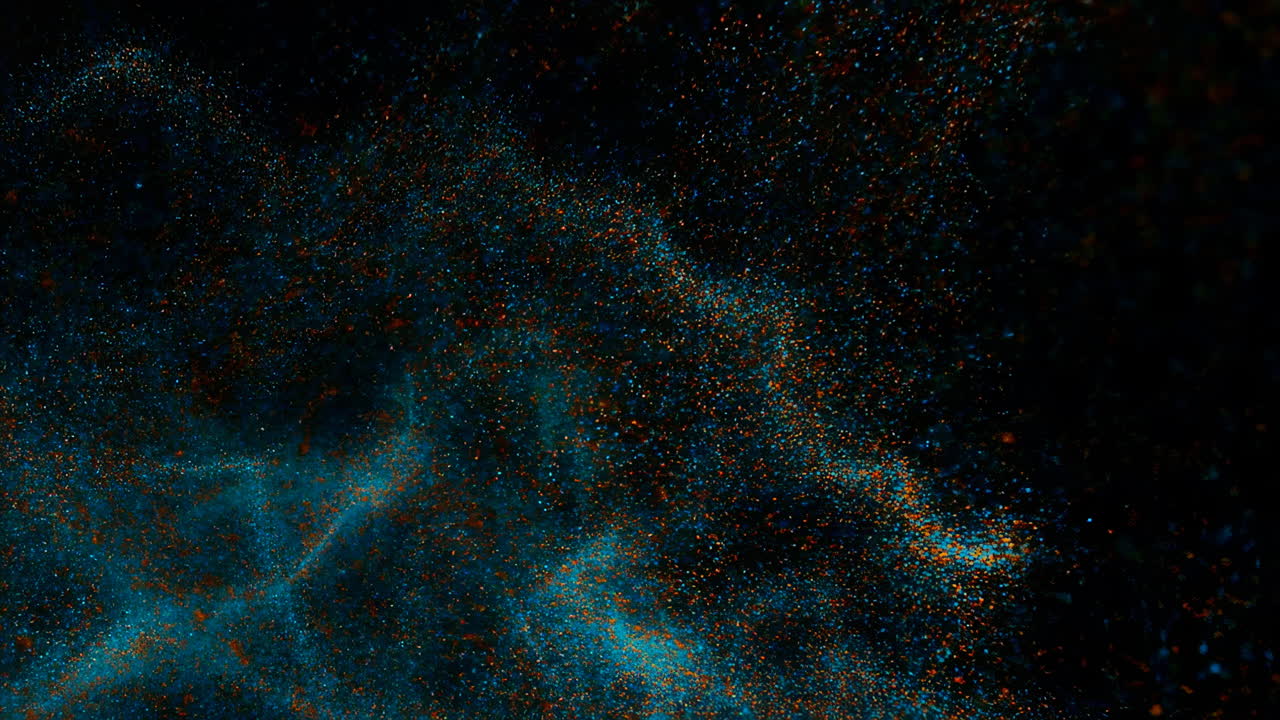 Kosmisk partikelsky på sort lærred, turkis tågedis hvirvler med orange gnister og små støvpartikler.