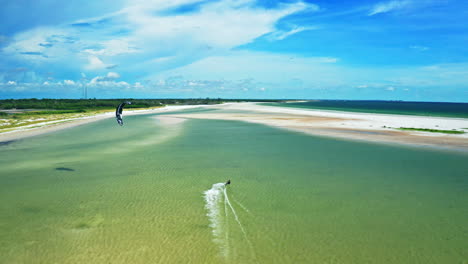 aerial following shot of lone kitesurfer practicing on shallow waters in florida