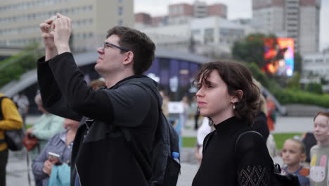 people taking pictures in a city park