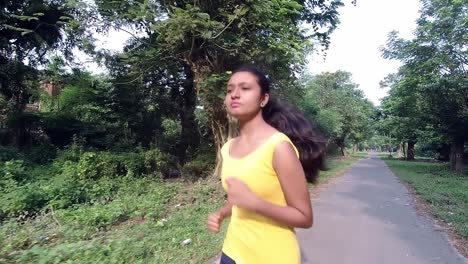 young indian teenager girl running or jogging at morning sunrise for body fitness, slow motion