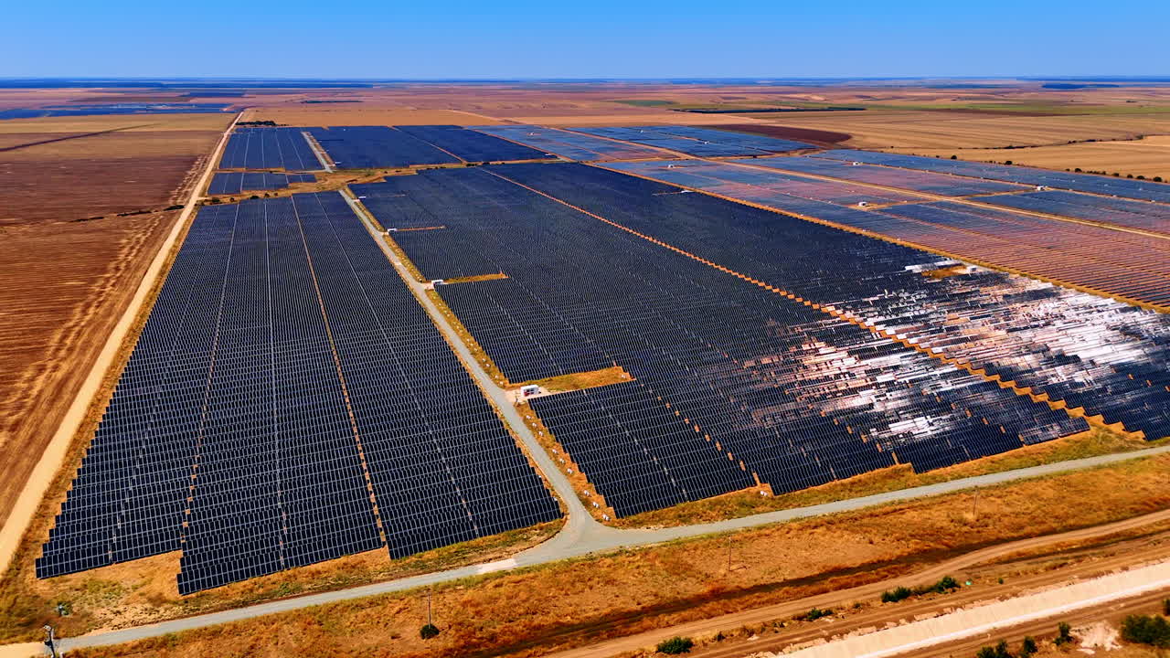 Solar panels farm with long perspective view. Solar farm rows extend into distance across flat terrain and dry fields