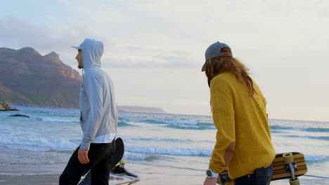 Seitenansicht-Junger-Kaukasischer-Freunde,-Die-Bei-Sonnenuntergang-4k-Gemeinsam-Am-Strand-Spazieren-Gehen