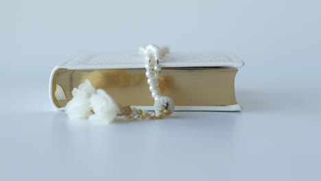 Holy-book-quran-and-rosary-on-table,-close-up