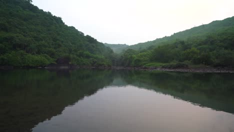 Magical-lake-surrounded-by-vast-jungle,-motion-forward-on-boat