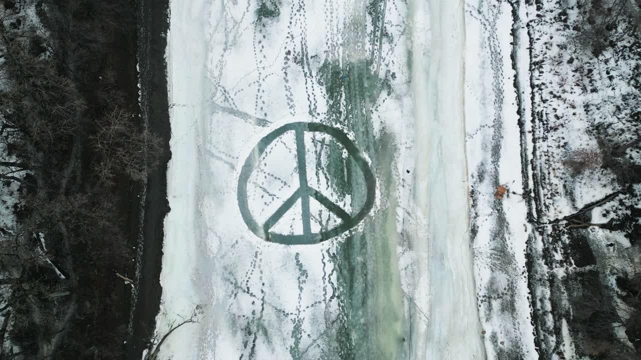 Slow Rising Establishing Drone 4k Shot of a Large Overhead Plowed Snow Peace Sign on Frozen Ice River Outdoors