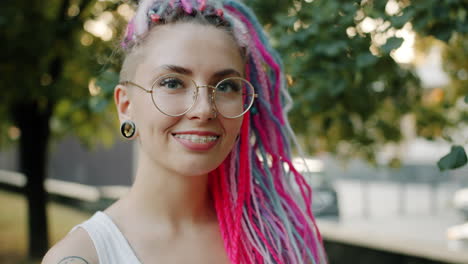 young woman with colorful dreadlocks and glasses