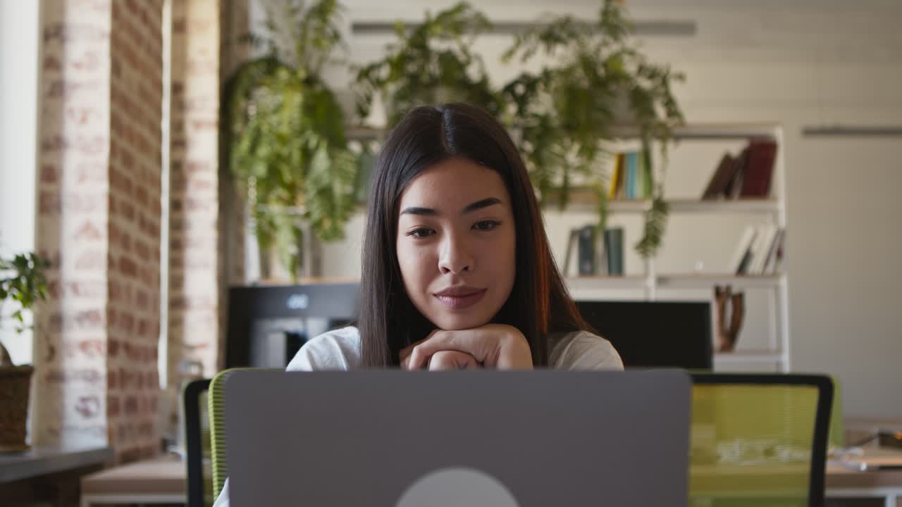 mujer trabajando en una computadora portátil en una oficina moderna