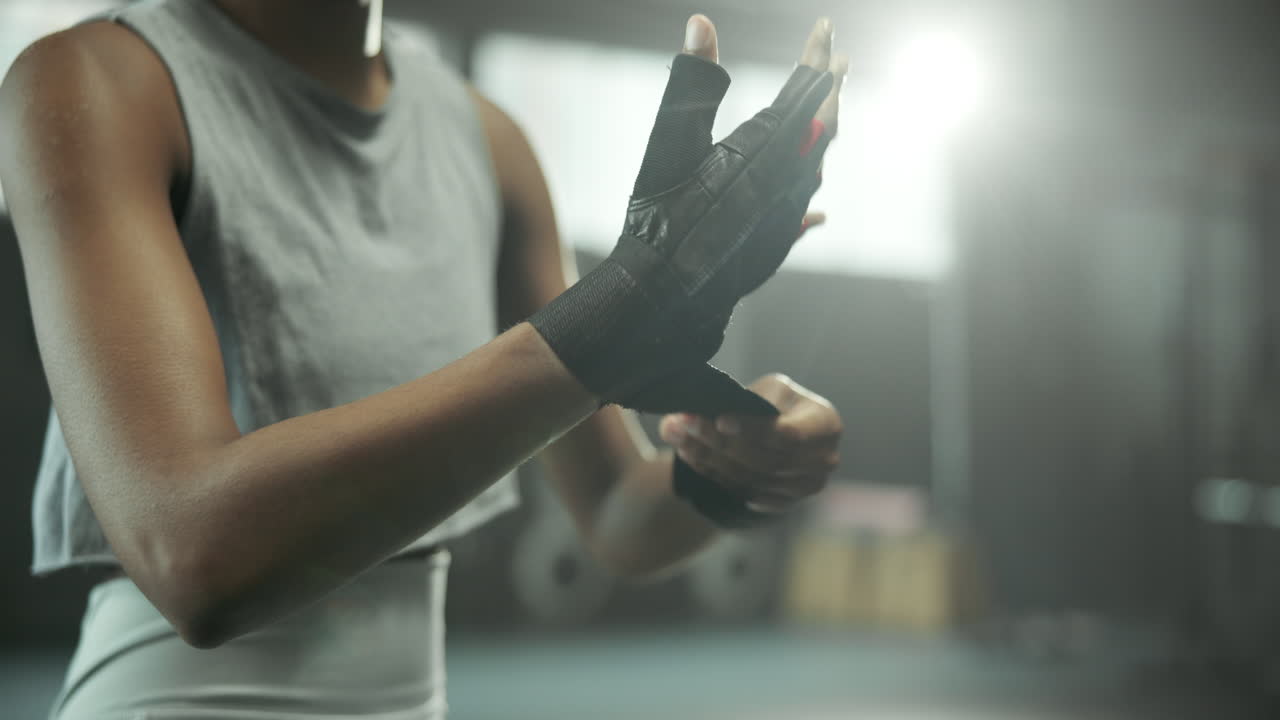 Woman preparing for workout with wrist wraps in the gym