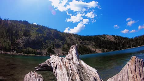 a time lapse of clouds rolling over mountain peaks by a lake