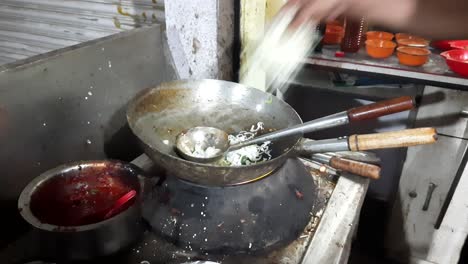 close up footage of an open restaurant where the chef is preparing noodles roadside in india with selective focus