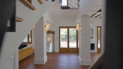 Slow-dolly-shot-of-the-front-door-of-a-villa-from-a-spiral-staircase