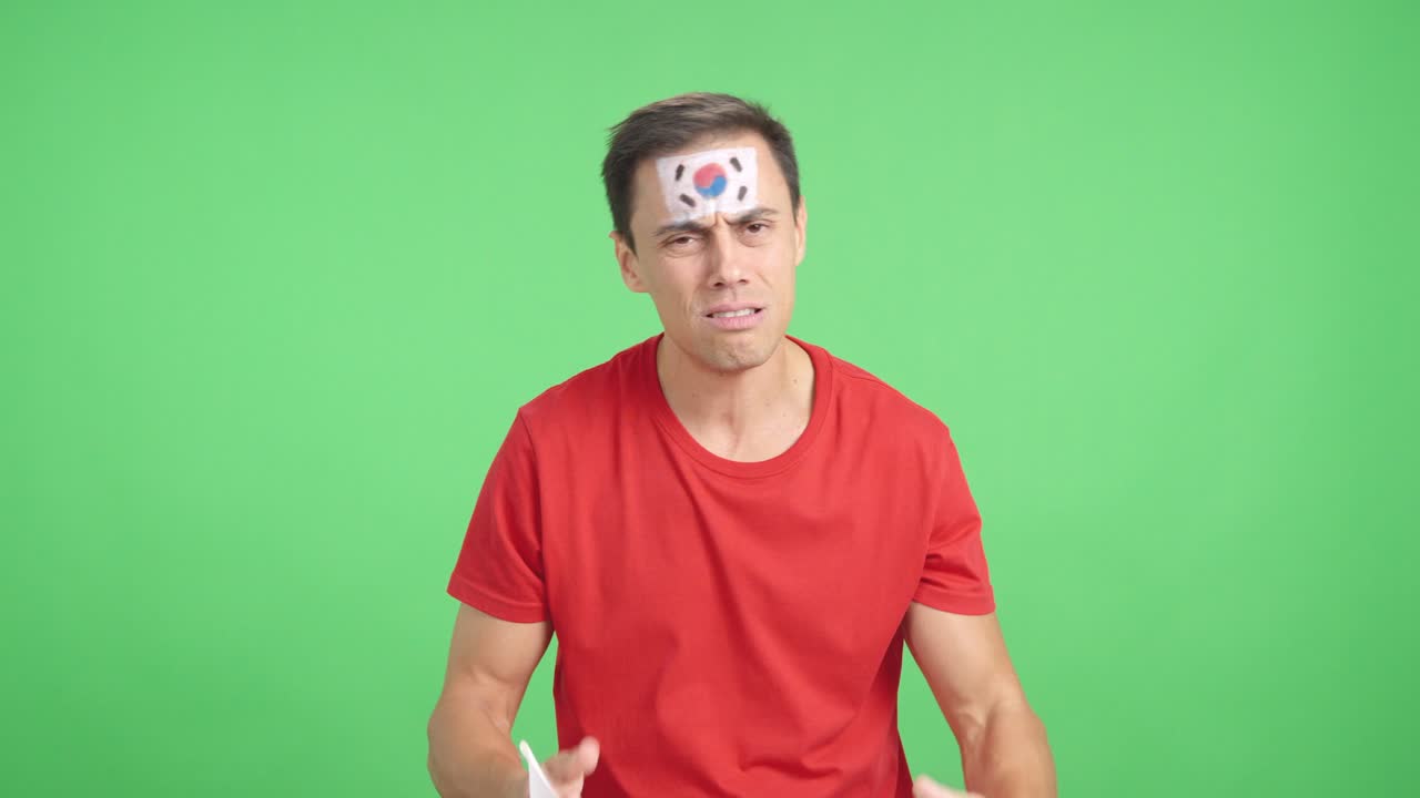 Man cheering for South Korea during a match that is lost