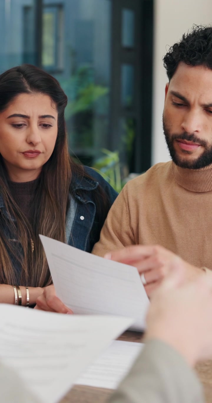 Giovane coppia che esamina documenti durante una consulenza professionale