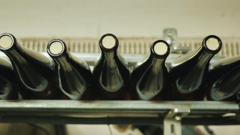 botellas de vino cerradas con un tapón de corcho se mueven a lo largo de la vista de la cinta transportadora desde arriba