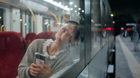 woman using smartphone on a train at night