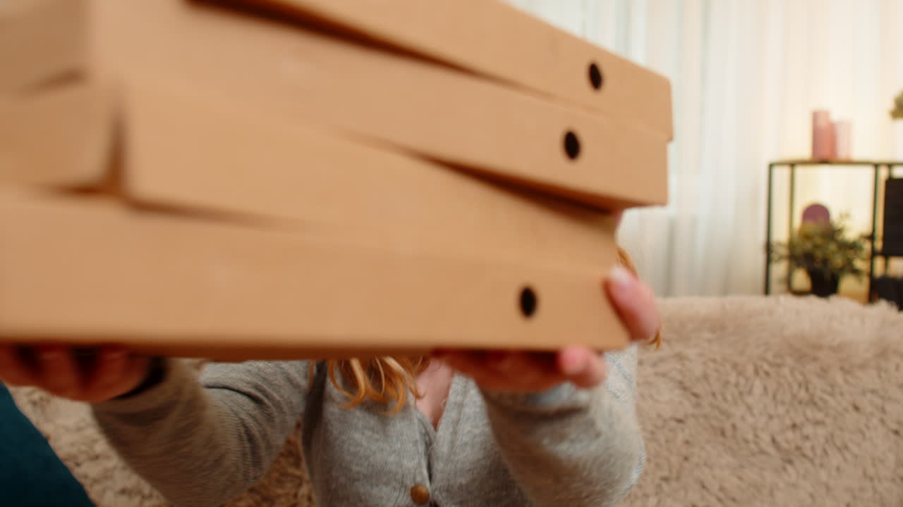 Pregnant woman receiving food delivery at home enjoying pizza with joyful smile and positive mood