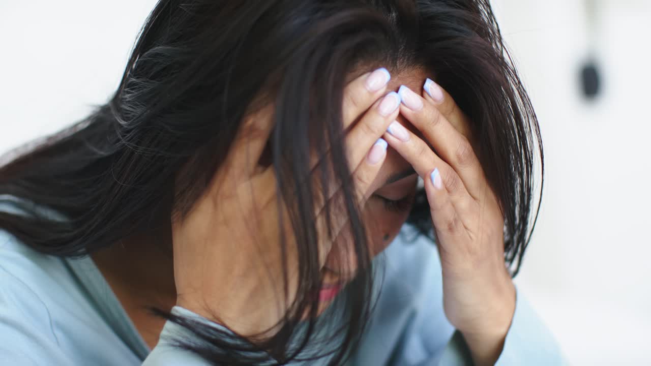 At start woman lifting hands pressing forehead massaging tension easing headache on white backdrop