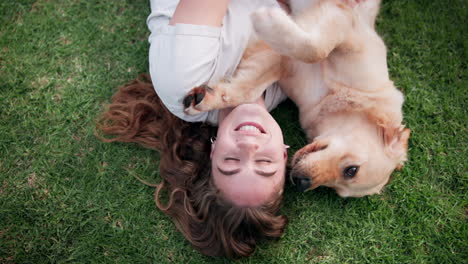 woman playing with her golden retriever on the grass