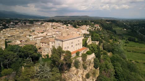 aerial rising shot revealing the lauris commune on a cliff in france