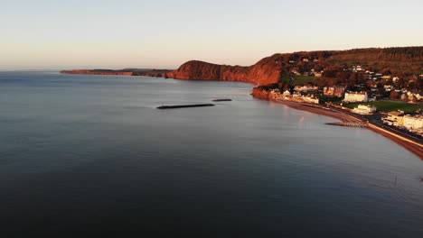 antena a lo largo de la costa de sidmouth con rompeolas en alta mar bañados por la luz dorada del amanecer