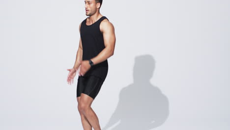 athletic young biracial man running in place on white background, with copy space