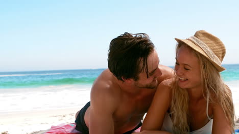una pareja acostada en la playa.